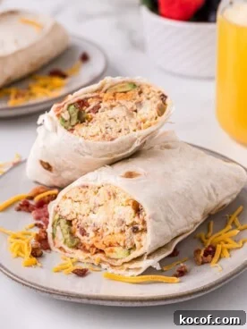 Make-Ahead Slow Cooker Breakfast Burritos for Busy Mornings 8 breakfast burritos sliced in half on plate
