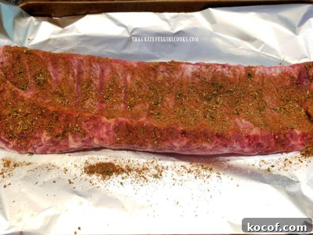 Baked Grilled Baby Back Ribs - The Grateful Girl Cooks! Light coating of seasoning covers the bone side of the rack of ribs.