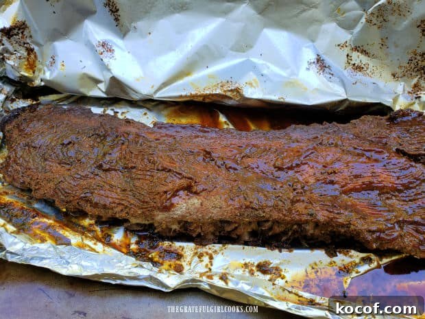 Baked Grilled Baby Back Ribs - The Grateful Girl Cooks! BBQ sauce is liberally applied to the baked baby back ribs.