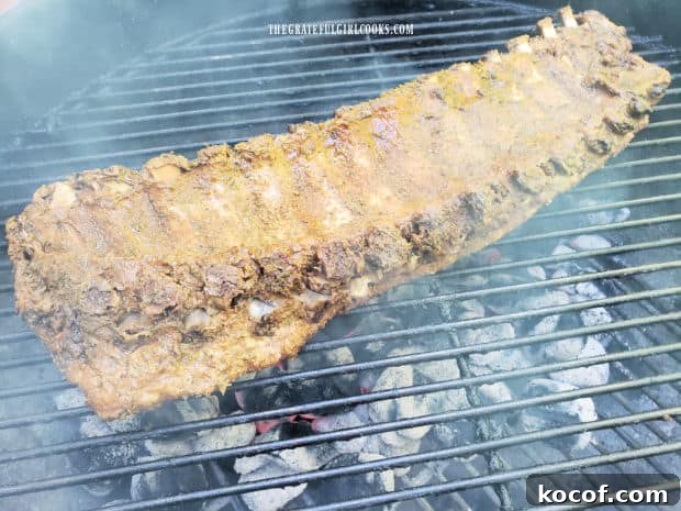 Baked Grilled Baby Back Ribs - The Grateful Girl Cooks! Rack of ribs is placed, BBQ sauce side down on a hot BBQ grill.