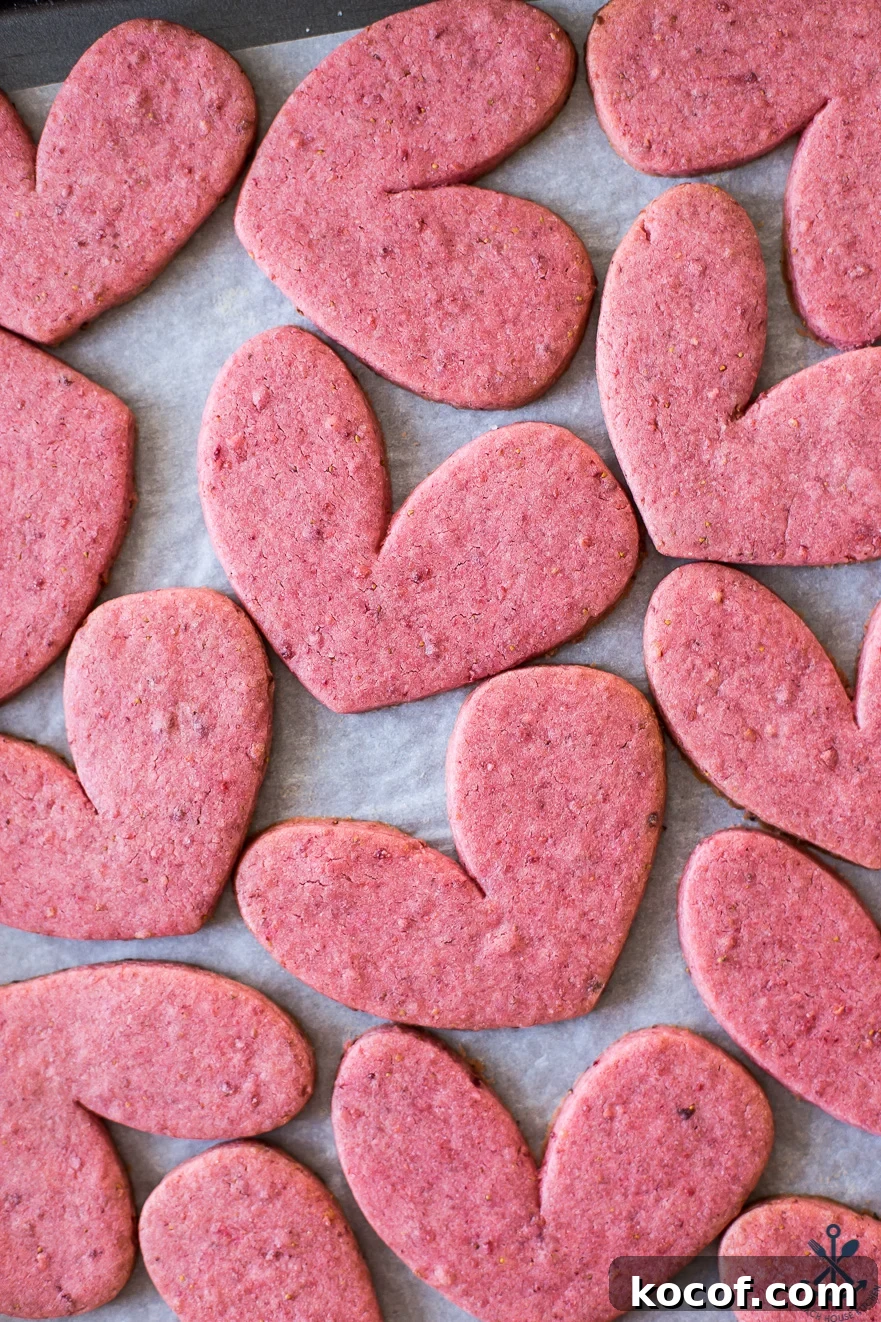 Up close overhead photo of a tray of pink heart sugar cookies