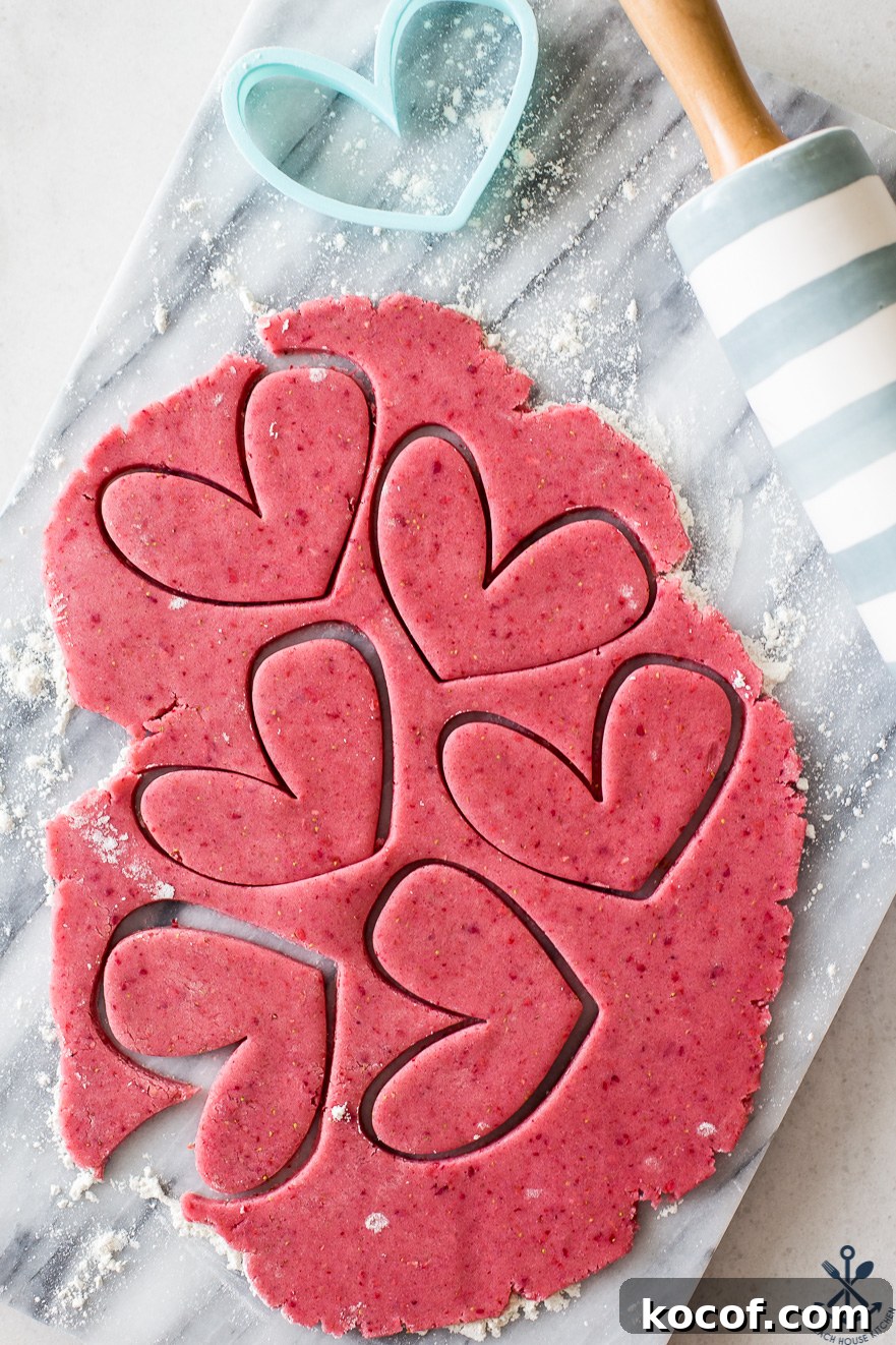 Strawberry Lemon Sugar Cookies Recipe with Fresh Fruit Zest 5 Overhead photo of pink cookie dough with heart cutouts on a marble board