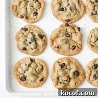 Chewy Gluten-Free Chocolate Chip Cookies Recipe 5 A speckled cookie sheet with baked chocolate chip cookies on it.