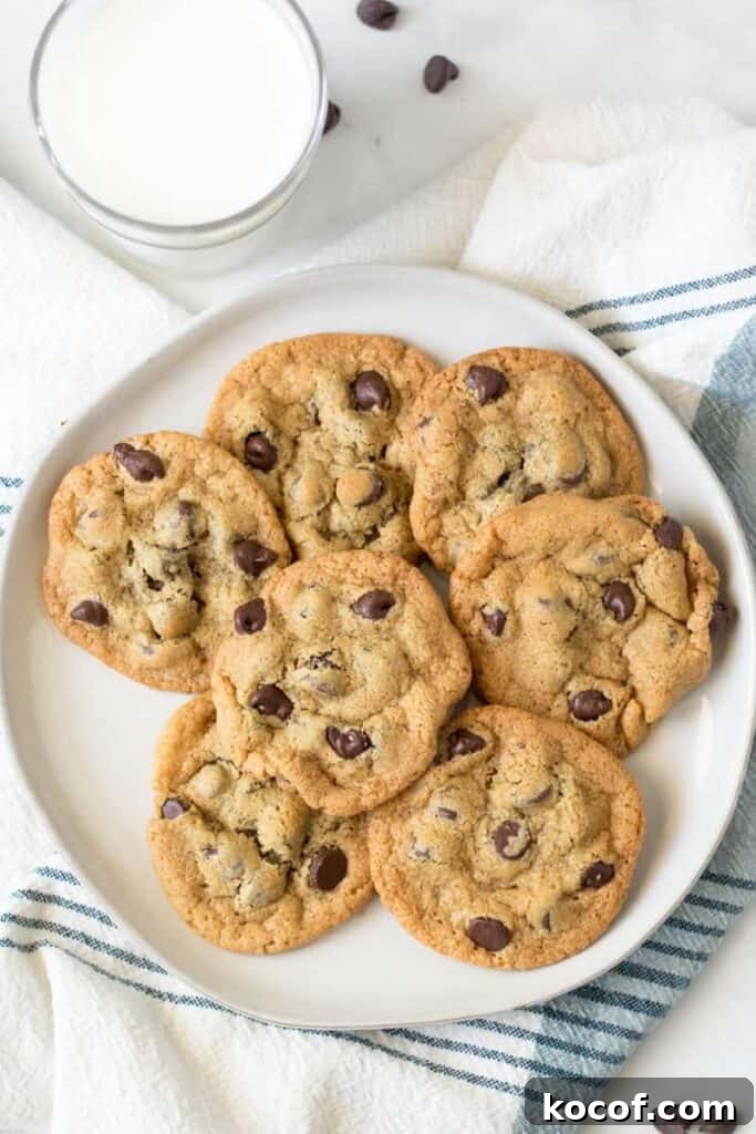 Chewy Gluten-Free Chocolate Chip Cookies Recipe 6 A plate full of chocolate chip cookies next to a glass of milk.