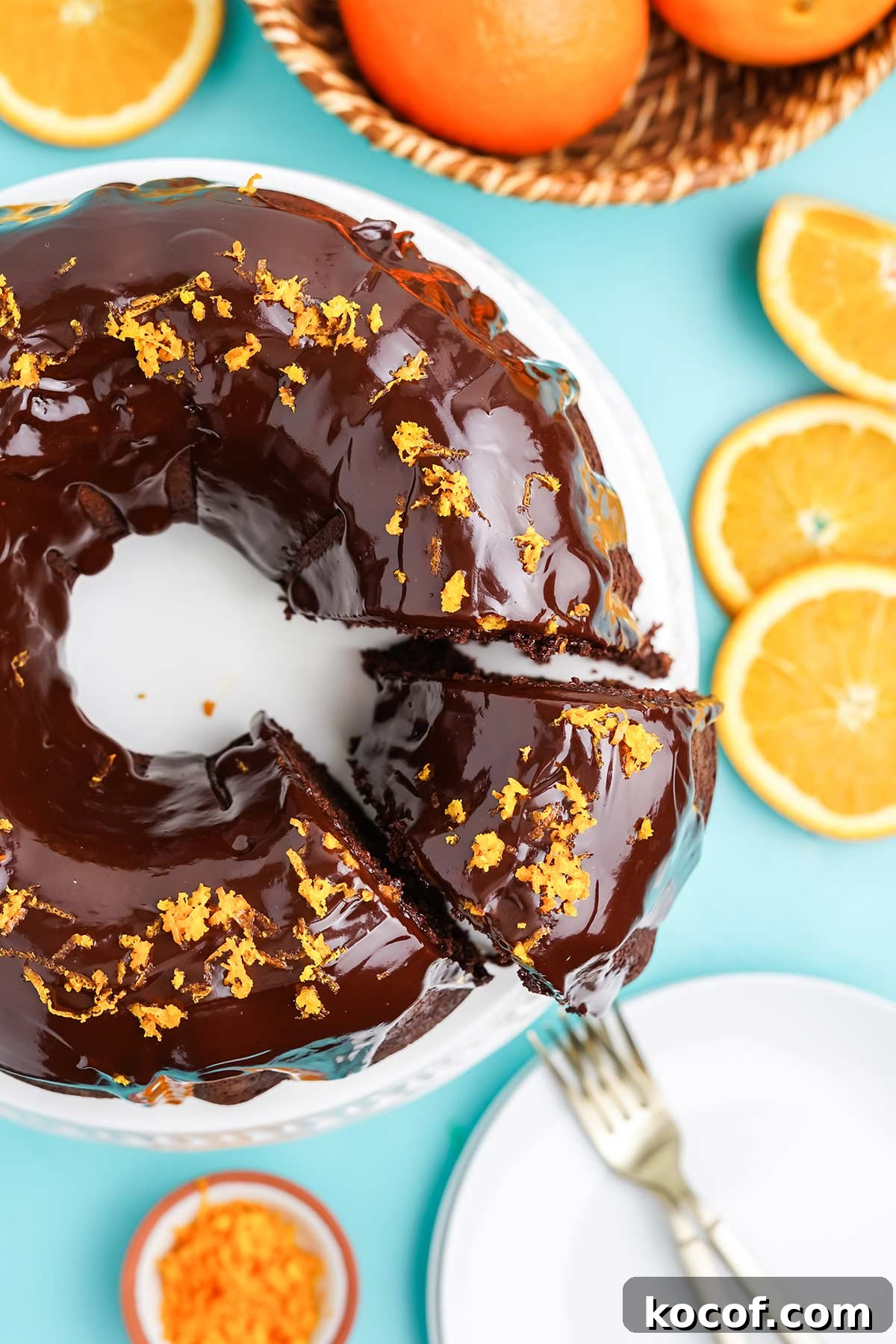 Chocolate and orange cake on the table with a slice cut and slightly pulled out from cake.