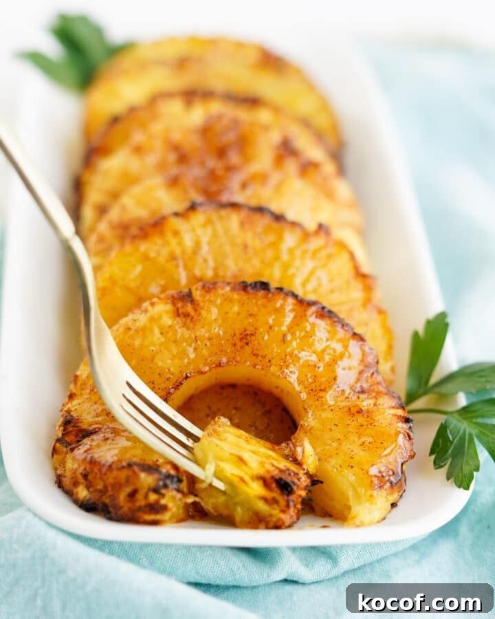 caramelized pineapple rings on white platter with fork