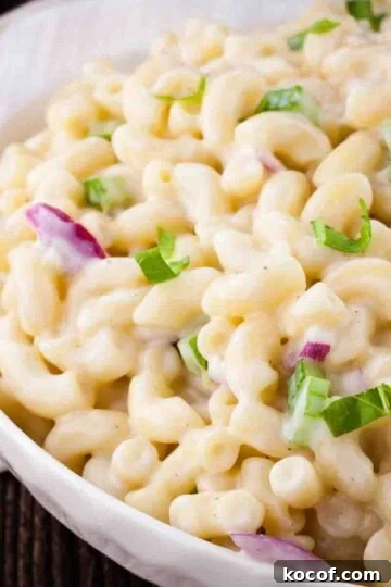 The macaroni salad in a white serving dish, topped with chopped fresh parsley.