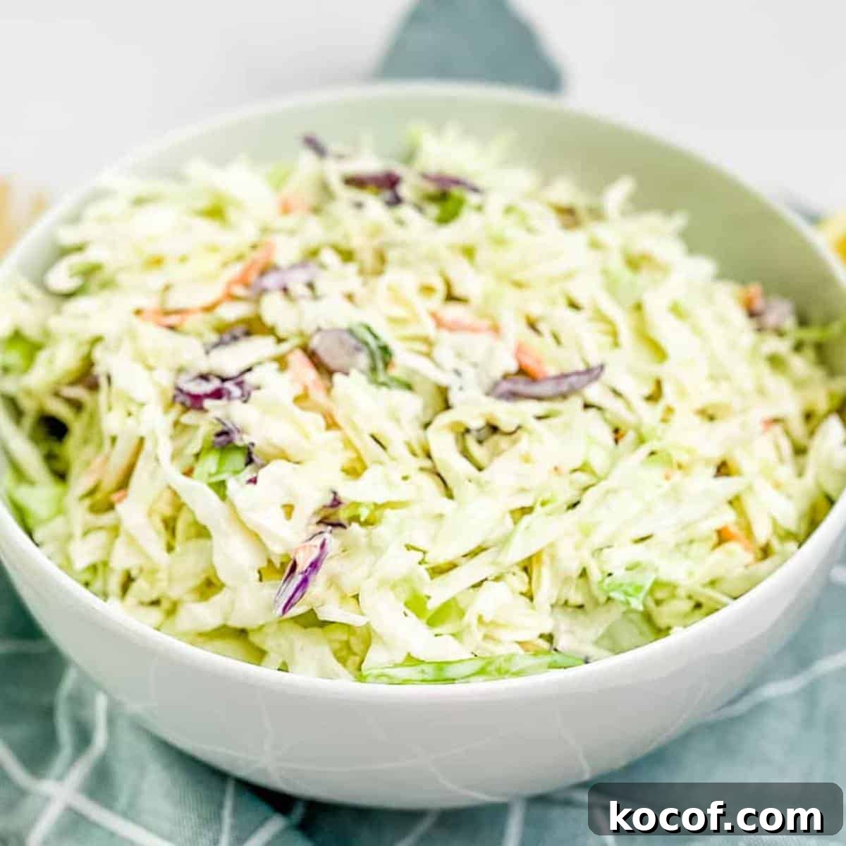 The prepared slaw transferred to a white serving bowl.