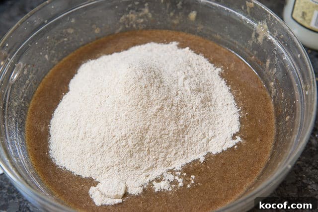 Wet Ingredients and Flour Dry Ingredients On Top in Glass Bowl