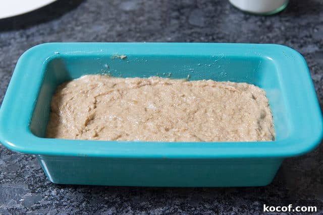 Coconut Oil Based Banana Bread Batter Spread Evenly in Blue Loaf Pan