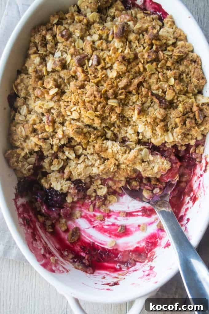 Mixed Berry Crisp Recipe: Quick Summer Dessert with Oats 5 Triple Berry Crisp in a white baking pan with half of crisp eaten