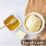 bowl of honey butter with honey and butter cube next to it
