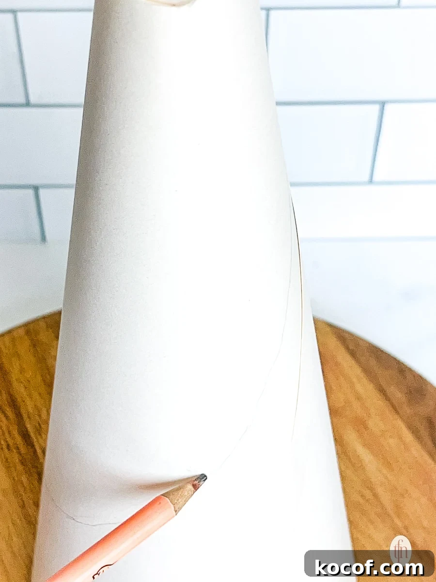 Drawing a line on a styrofoam cone with a pencil.