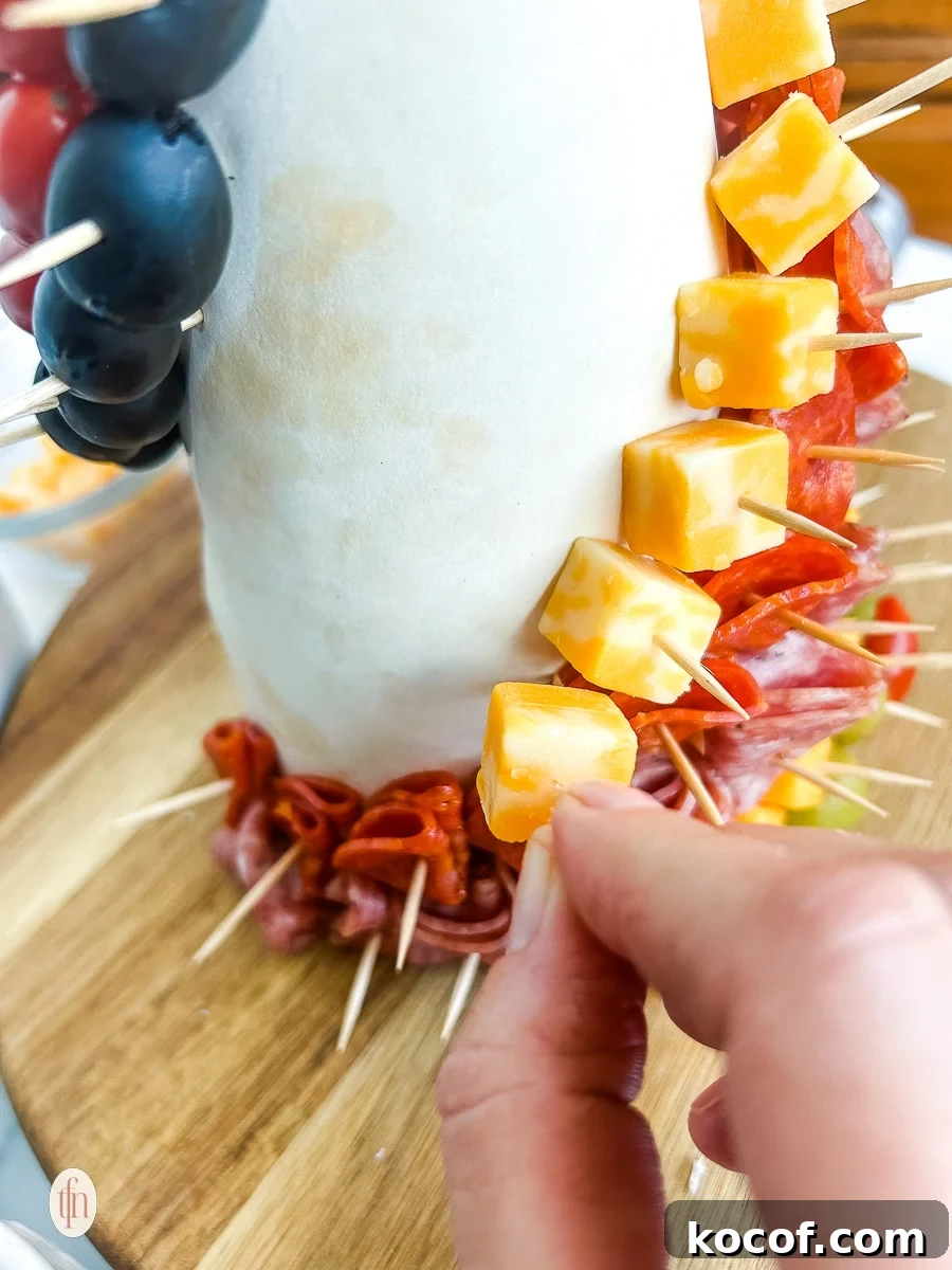 Placing a cube of cheese on a cone with a toothpick.