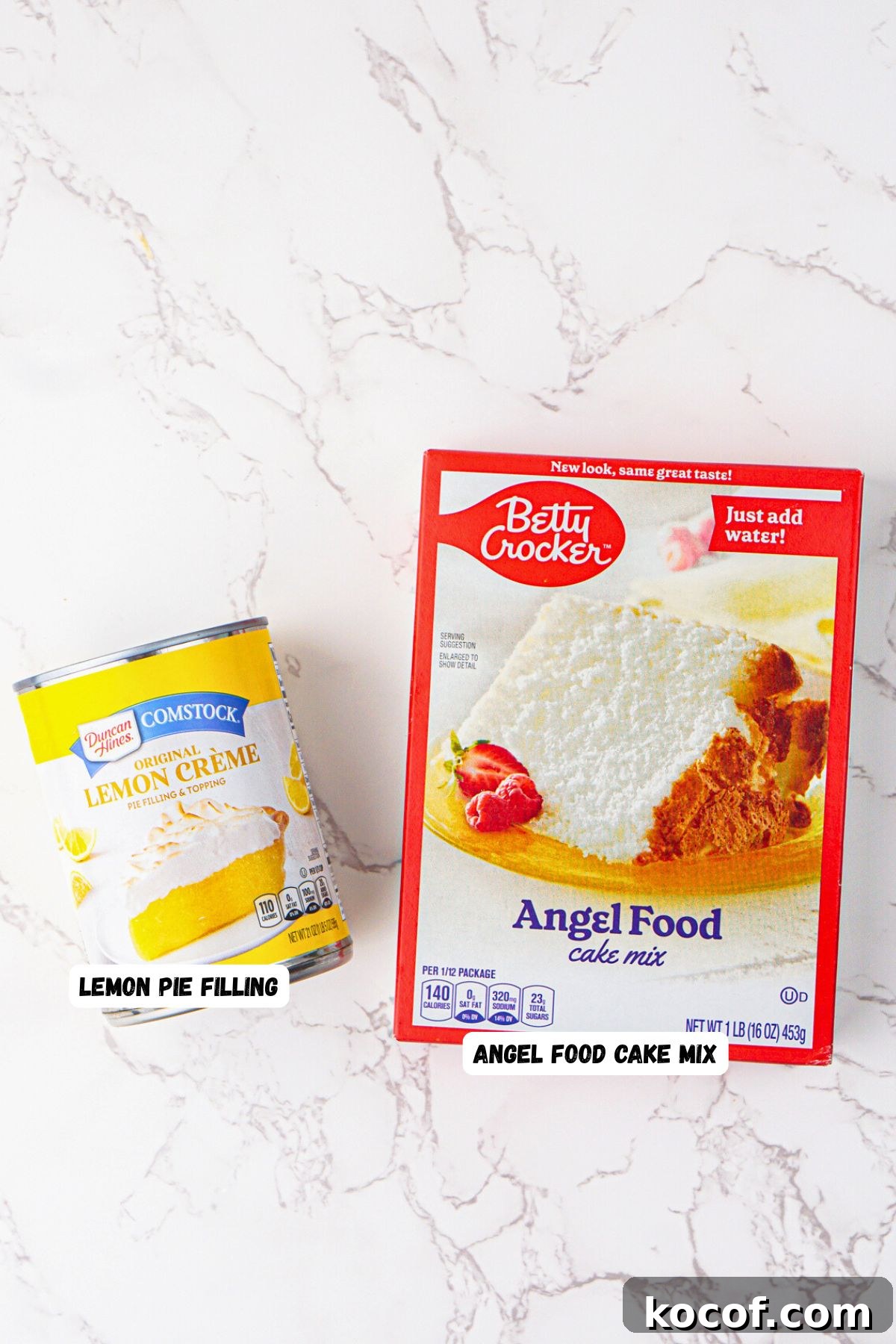 Box of angel food cake mix and can of lemon pie filling on a white marble table. 