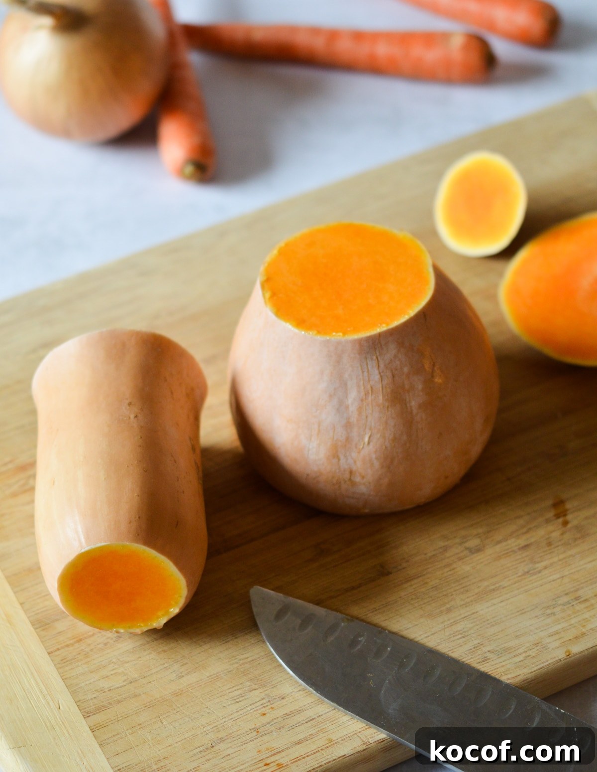 butternut squash cut in half on a cutting board.