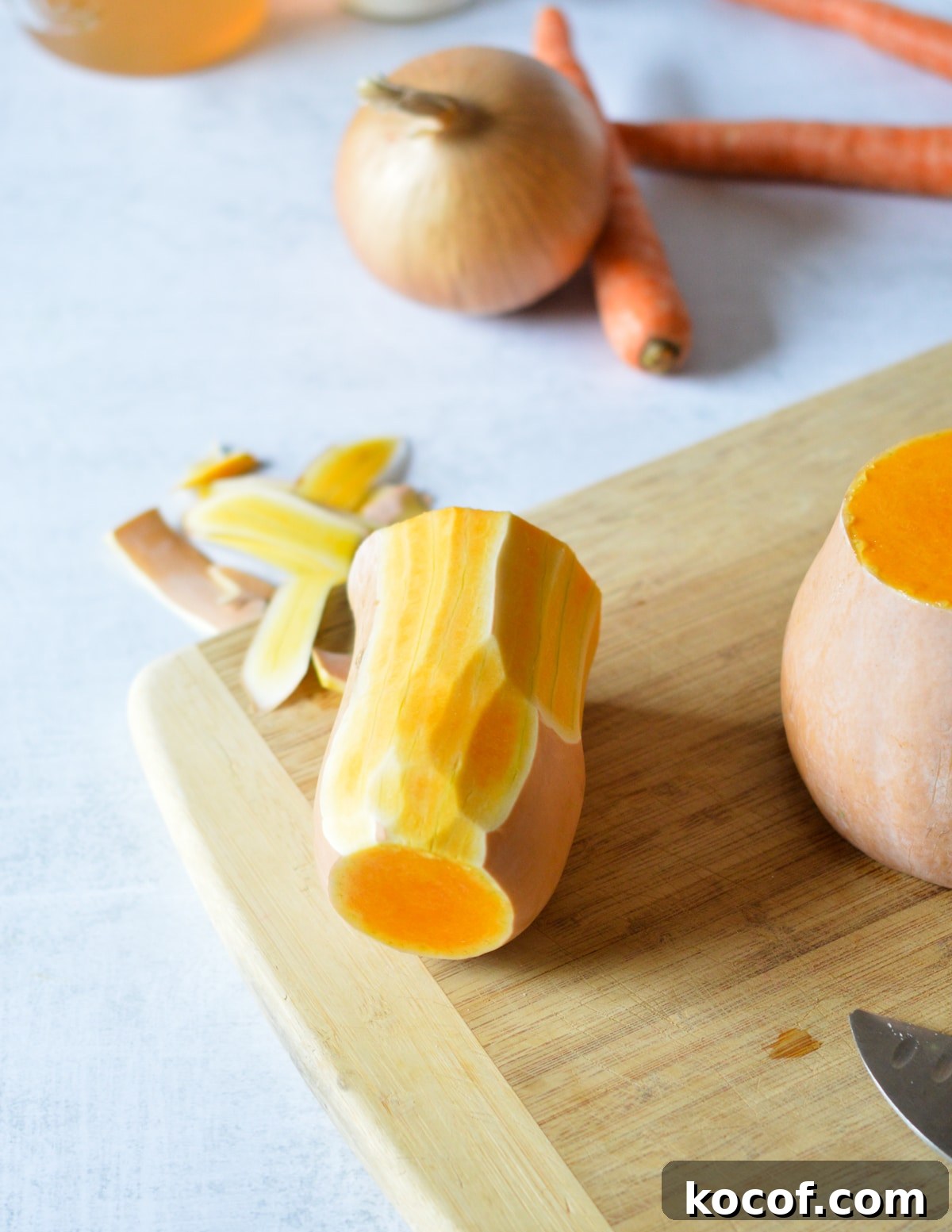 peeled butternut squash neck on a cutting board. 