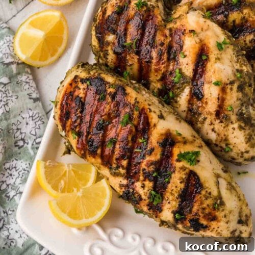 9 Juicy Grilled Chicken Recipes That Stay Moist Every Time 11 Juicy grilled chicken breasts with herbs and lemon slices on a serving plate.