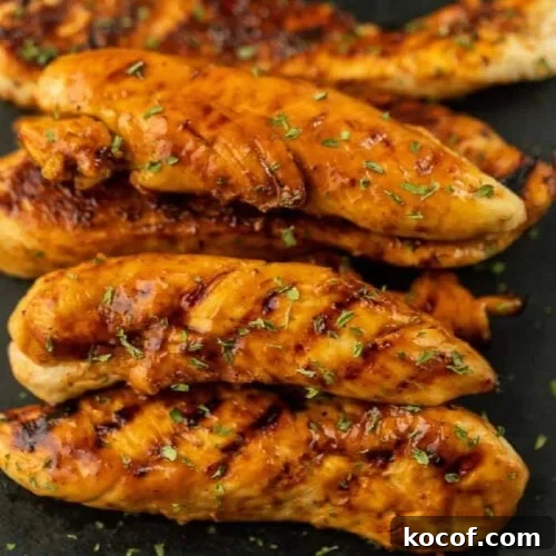 9 Juicy Grilled Chicken Recipes That Stay Moist Every Time 4 Juicy grilled chicken tenders with herbs on black plate.