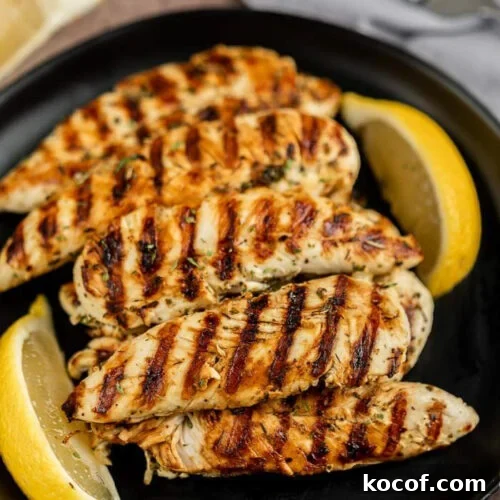 9 Juicy Grilled Chicken Recipes That Stay Moist Every Time 5 Grilled chicken with lemon wedges on black plate, cooked to perfection with grill marks.