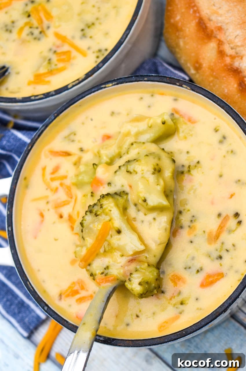 Copycat Panera Broccoli Cheddar Soup Recipe 8 a silver spoon holding up a scoop of homemade broccoli cheddar soup