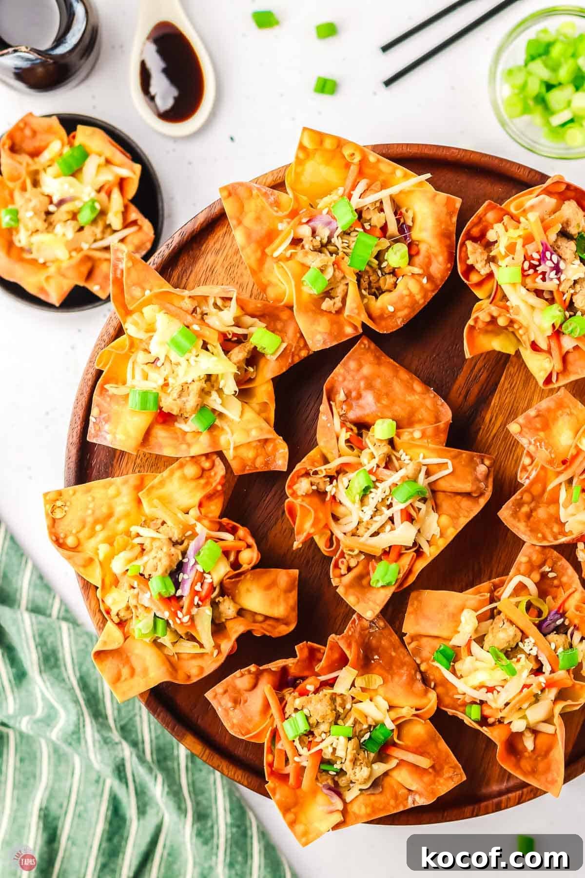 overhead picture of egg roll cups on a round wood cutting board