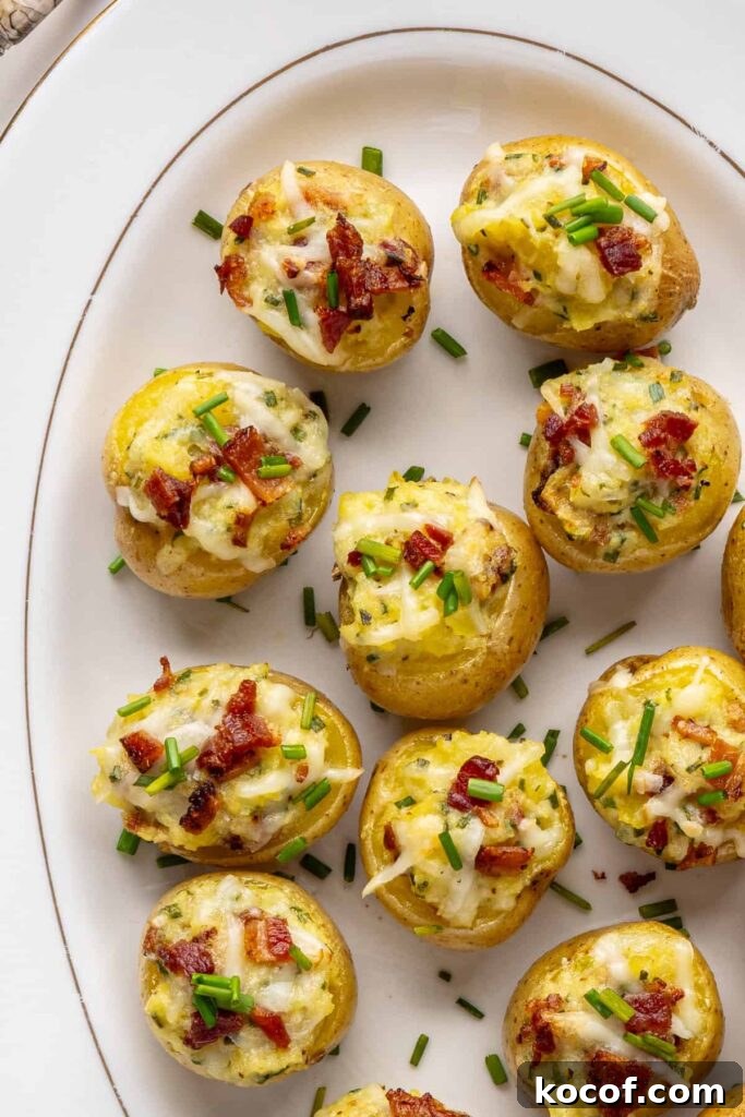 Close-up overhead of golden brown twice baked potatoes with cheesy filling, chives, and crispy bacon