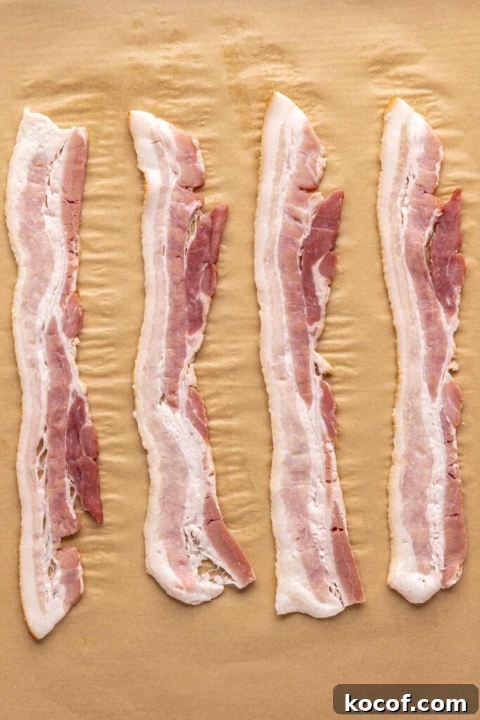 Applewood smoked bacon on parchment-lined baking sheet before baking