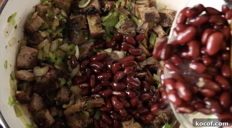 Smoked Brisket Chili Recipe: Bold, Smoky Chili with Beef Brisket 5 red kidney beans being poured into base of smoked brisket chili