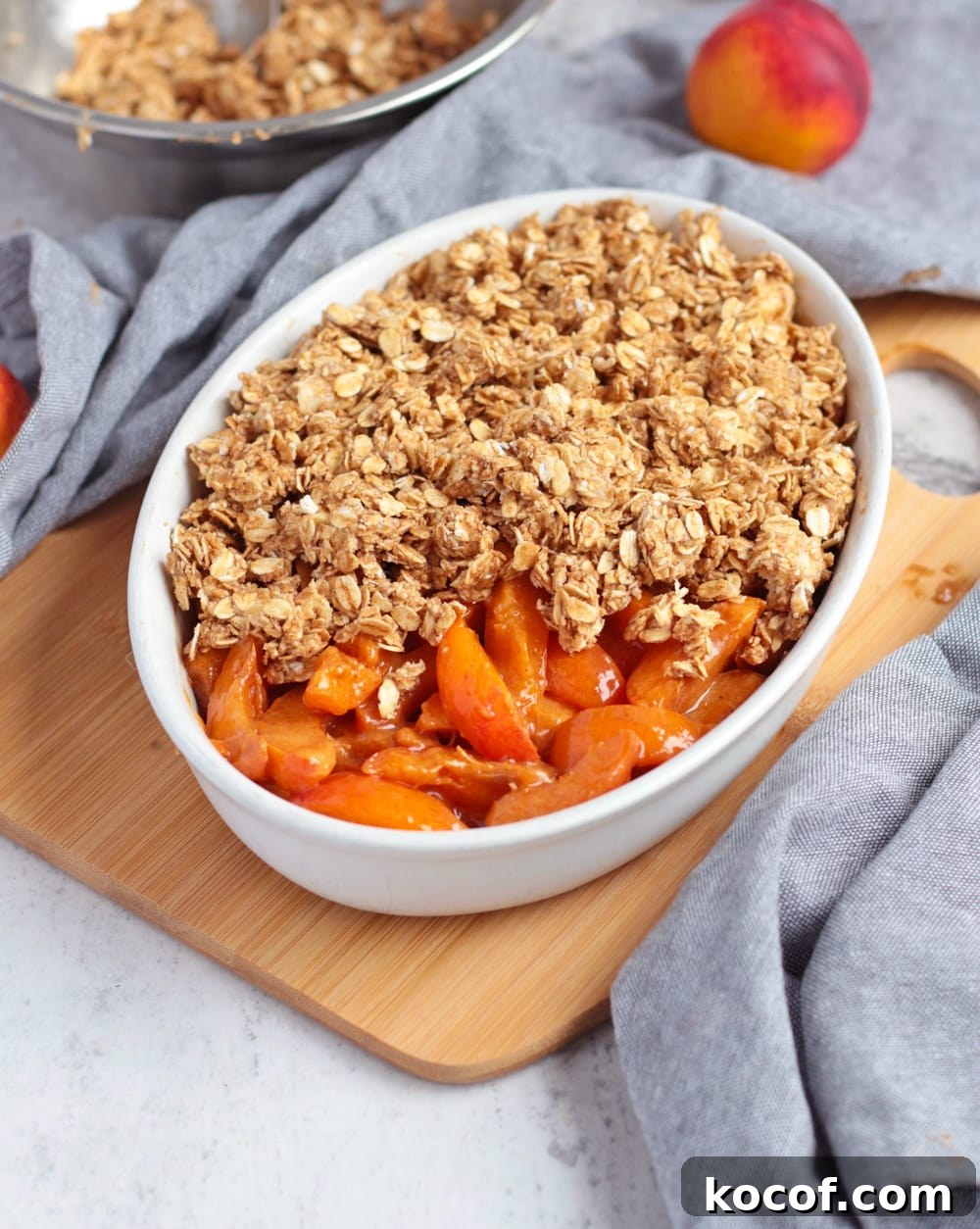 Apricot Crumble with Crunchy Oat Topping 5 Apricot filling in a ceramic dish half covered by the crumble topping