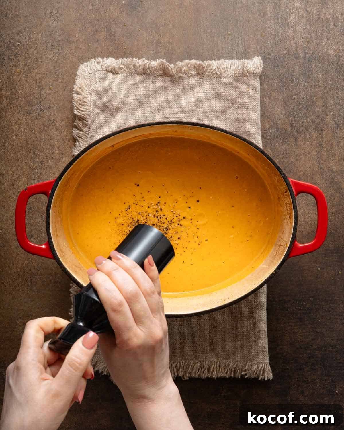pepper being added to sweet potato soup.