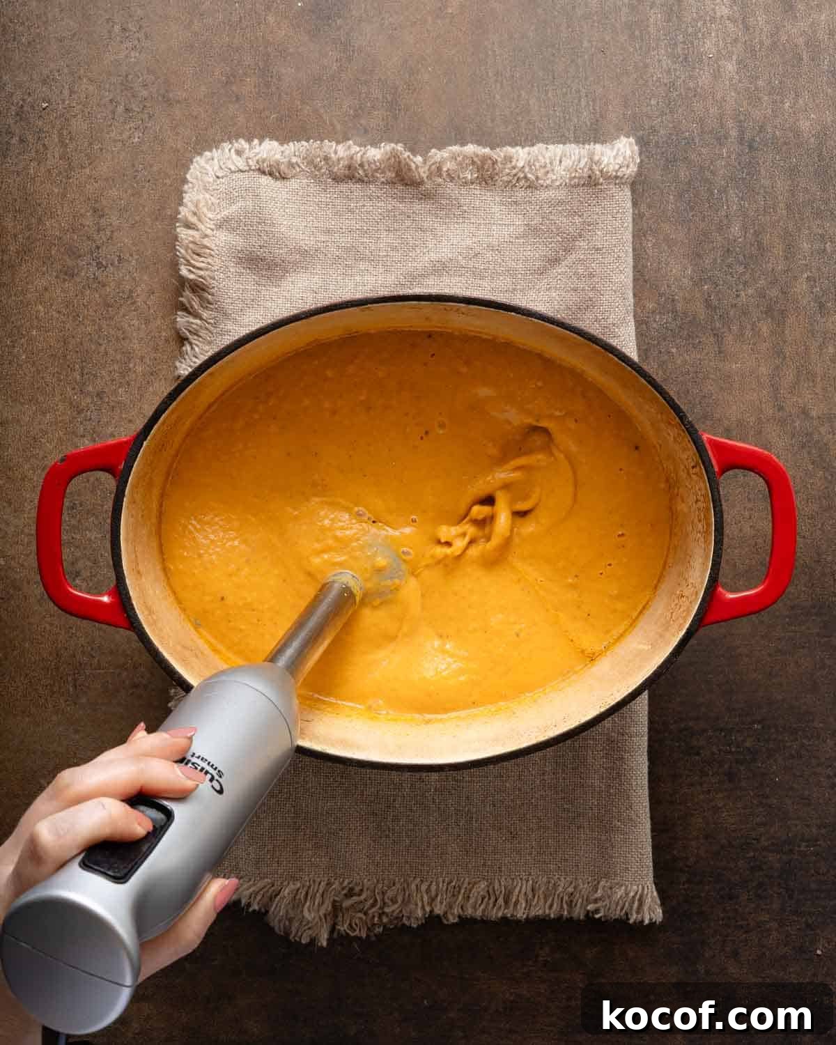 sweet potato pumpkin soup being blended with stick blender.