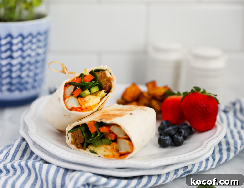 A burrito on a plate with blueberries, strawberries, and breakfast potatoes