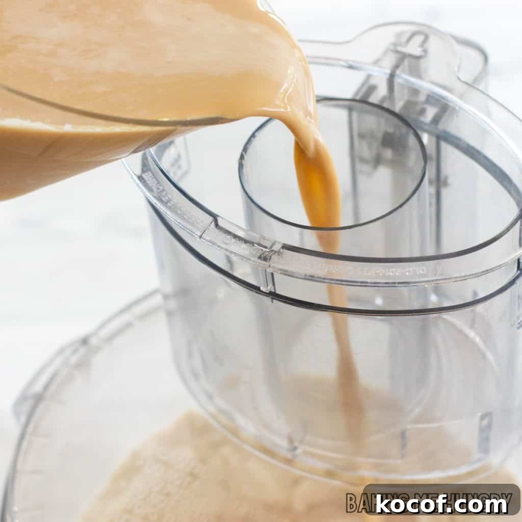 creamy espresso mixture being poured into food processor shoot