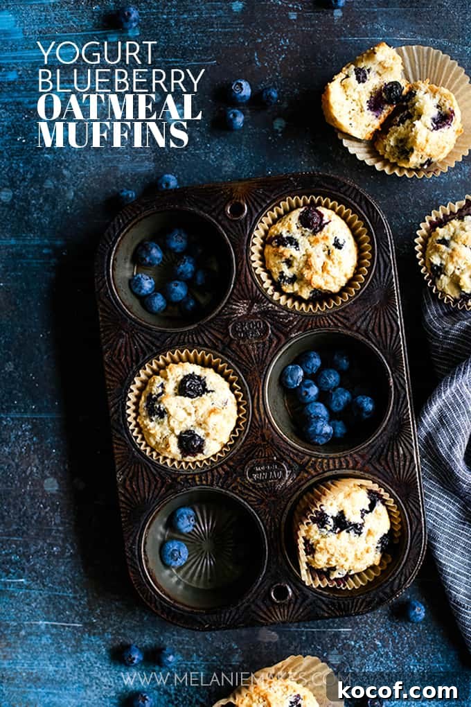 Yogurt Blueberry Oatmeal Muffins and blueberries in a muffin tin.