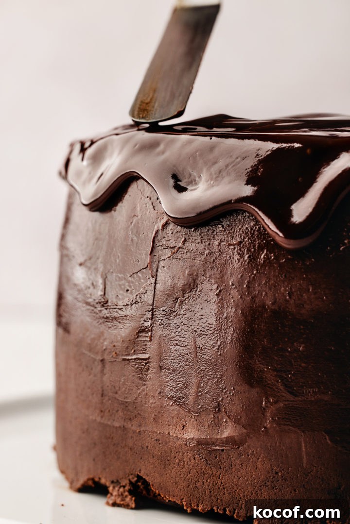 drizzling chocolate ganache onto a chocolate cake
