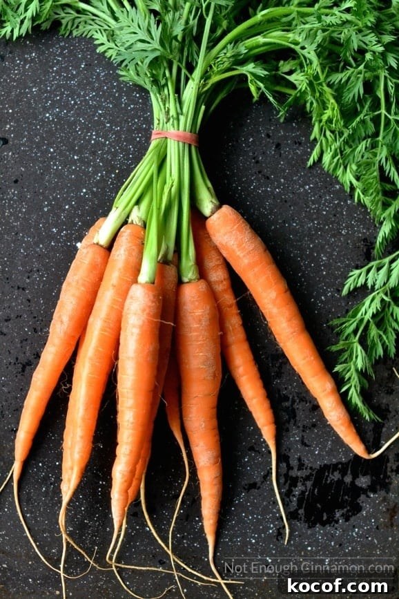 Balsamic-Glazed Roasted Carrots with Honey and Herbs 3 a bunch of fresh carrots on a dark tabletop ready to be roasted
