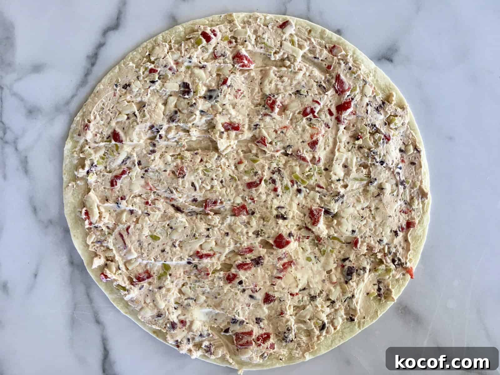 cream cheese mixture spread on top of tortilla. 