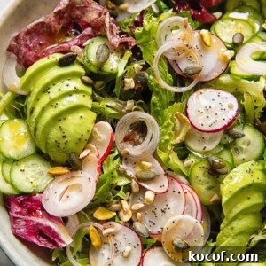 Fresh Garden Salad Recipe: Crisp Mixed Greens & Simple Dressing 6 Close up shot of garden salad with radish, cucumber and avocado topped with nuts and seeds