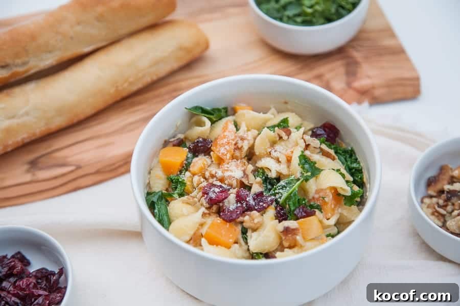 Creamy Roasted Butternut Squash Pasta with Sage and Parmesan 7 A bowl of creamy butternut squash kale pasta with a side of cranberries and pecans.