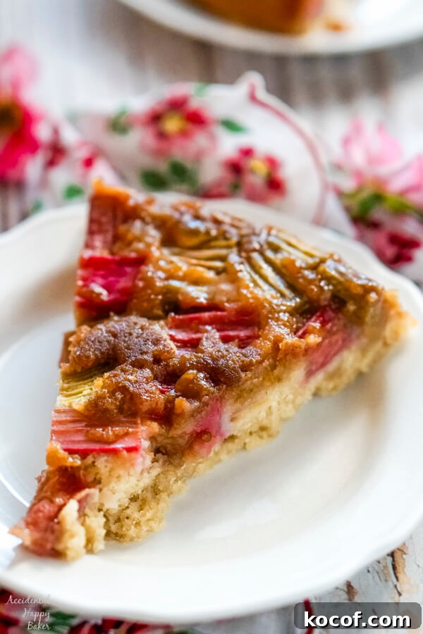 A slice of rhubarb ginger upside down cake on a white plate.