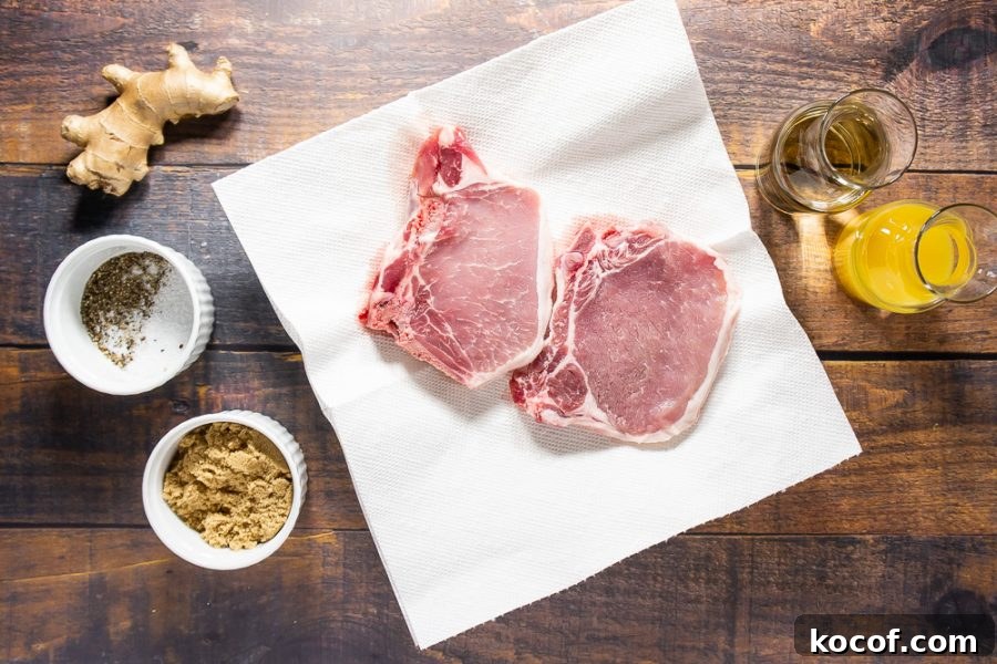 raw pork chops beside orange juice, wine, salt, pepper, fresh ginger, and brown sugar