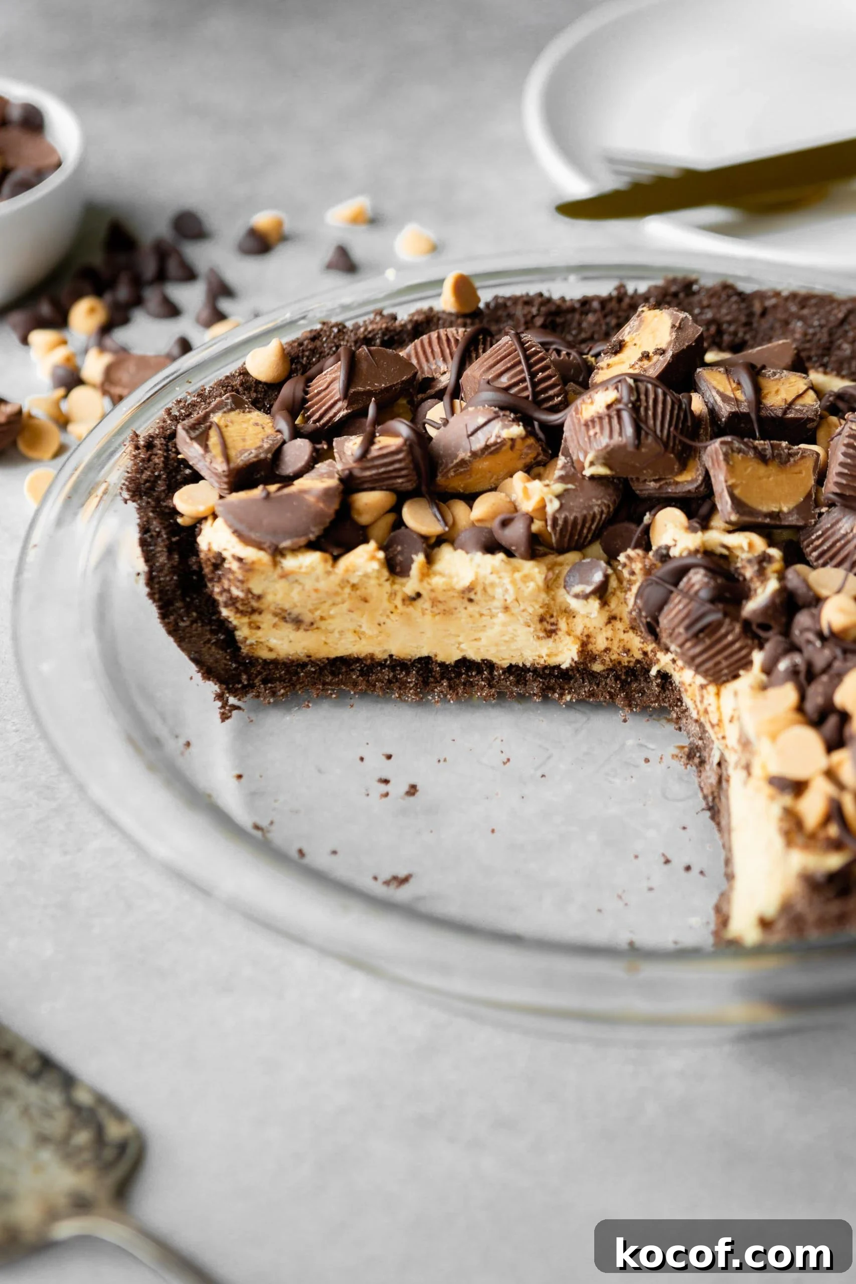 Glass pie plate with a missing portion of a chocolate peanut butter pie.