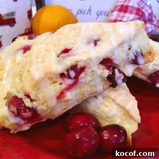 Cranberry Orange Scones stack with fresh cranberries around them.