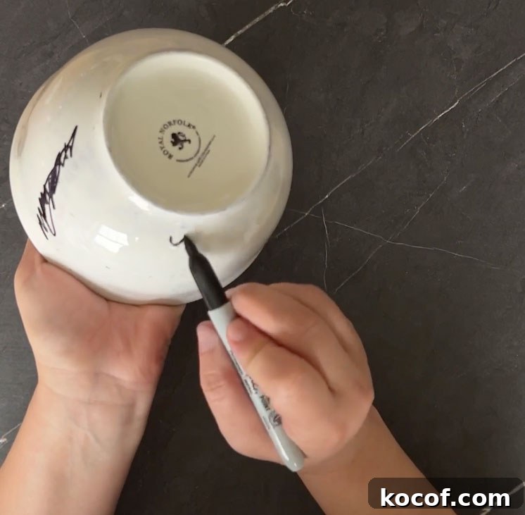 Create a Faux Marble Bowl: Step-by-Step DIY Tutorial 5 Hands drawing shapes on white bowl with black sharpie marker