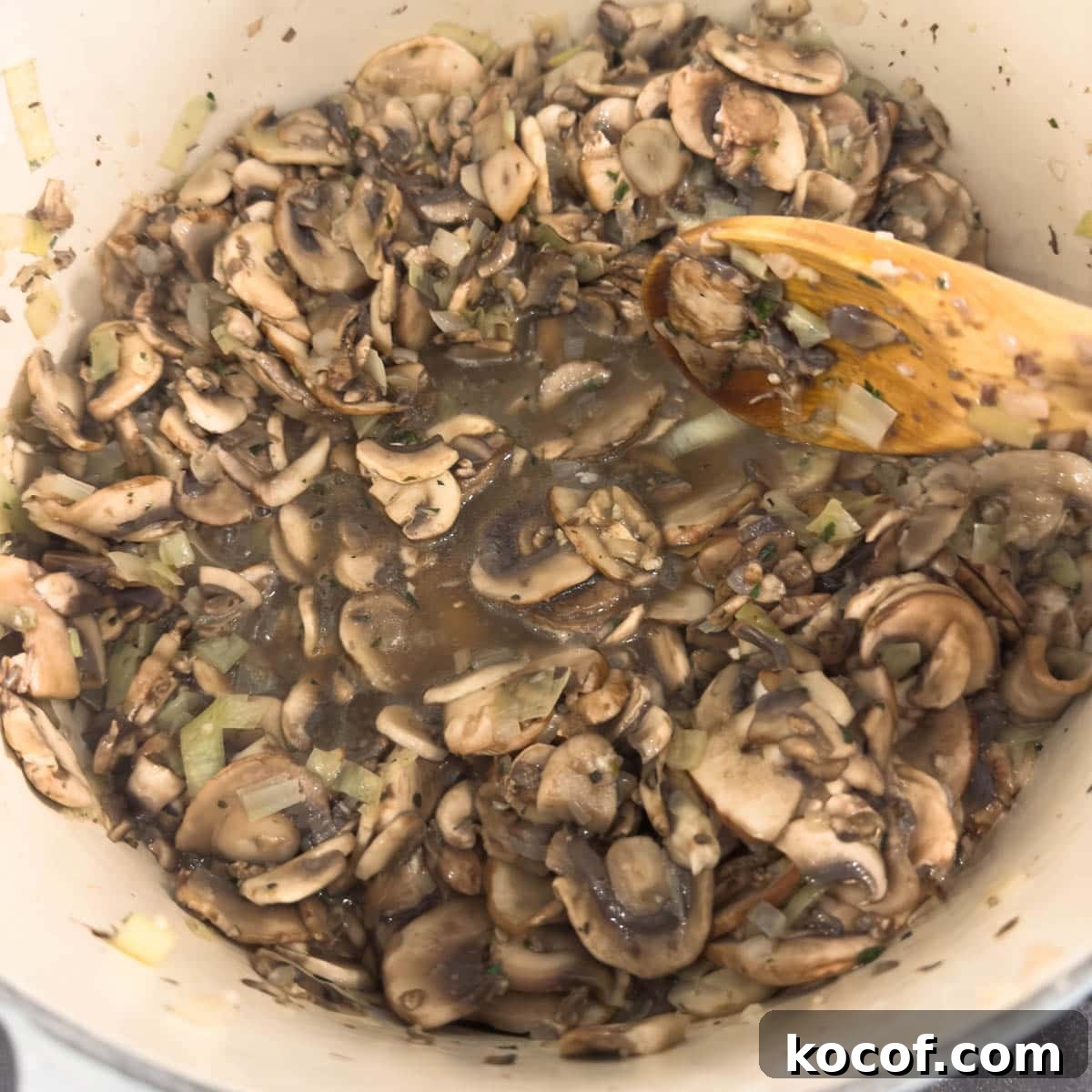 A heavy pot full of juicy cooking mushrooms as they give off their liquid.