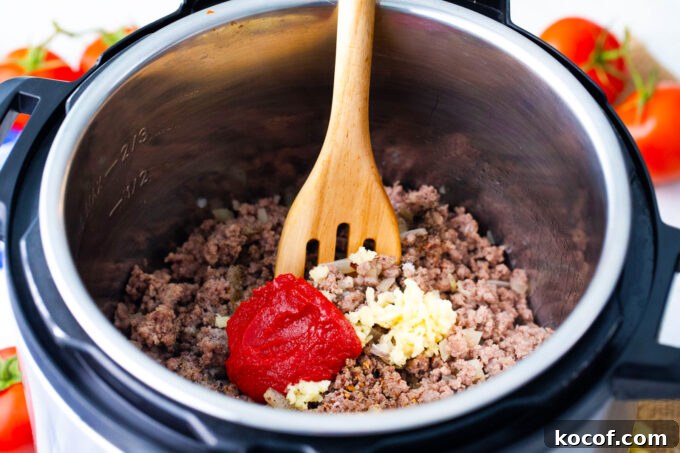 Searing ground beef with tomato paste and garlic in the instant pot.