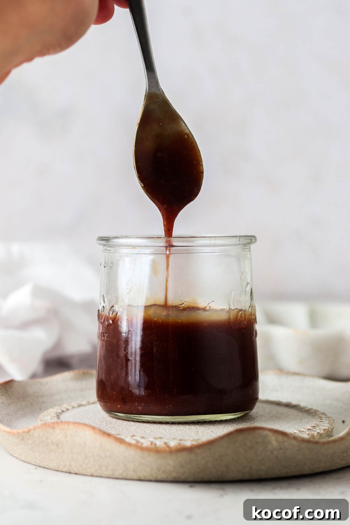 vegan caramel sauce 1 Vegan caramel sauce in a jar with a spoon.
