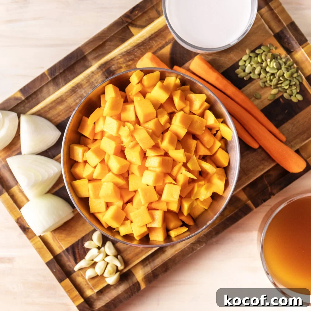 Creamy Butternut Squash and Carrot Soup Recipe for Fall 3 butternut squash and carrot soup ingredients. chopped butternut squash, 3 peeled carrots, coconut milk, chopped onion, fresh garlic cloves, pepitas, and chicken broth