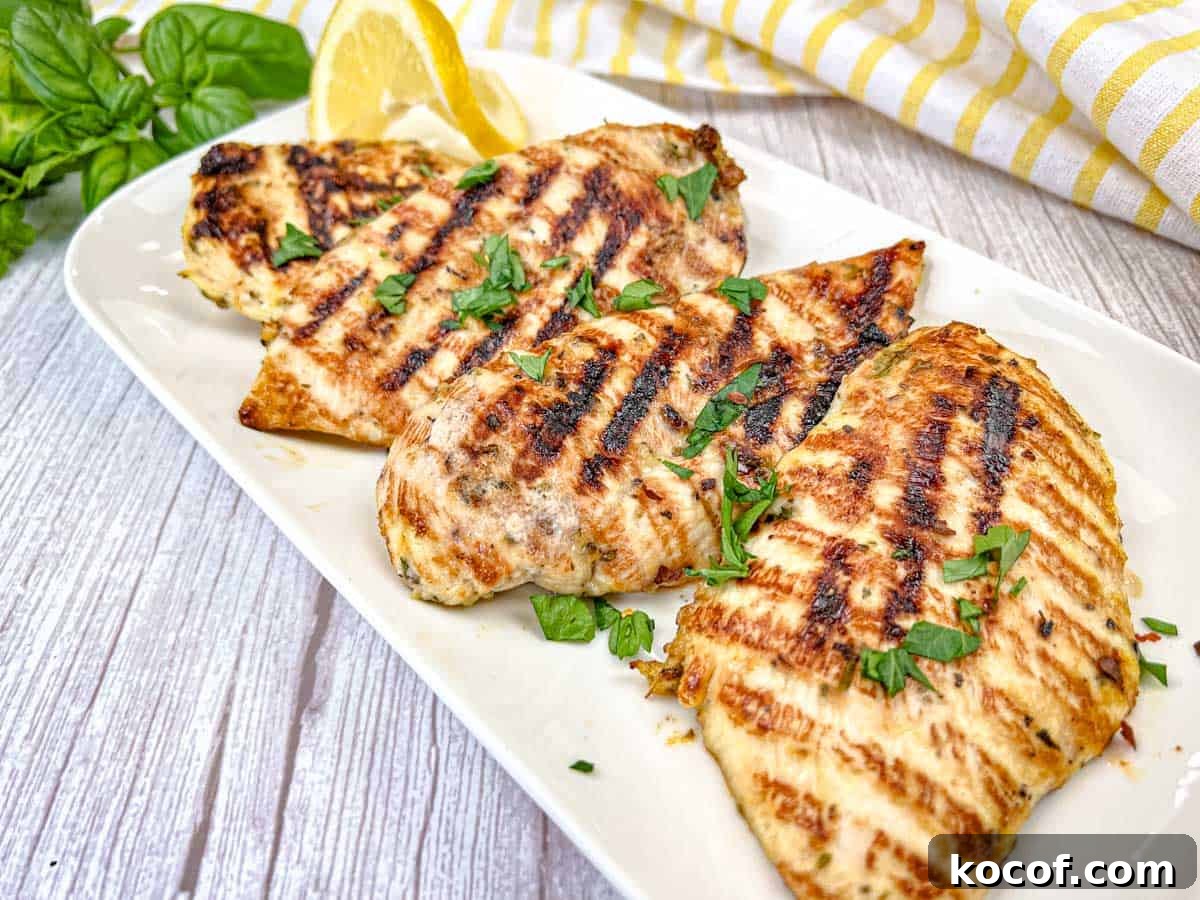 39 Outdoor Grilling Dinners That Make You Ditch the Oven Tonight 2 Four pieces of Ninja Woodfire Grill Lemon-Herb Chicken served on a white rectangular plate.